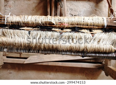 close-up parts of a manual small weaving machine and accessories for making traditional arts and crafts folklore textiles with natural hand made silk and cotton yarns in cultural village in THAILAND