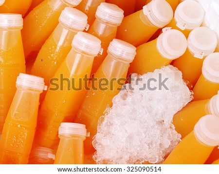 daily fresh homemade carrot pressed juice in plastic bottle in ice box for sale on a street market in THAILAND
