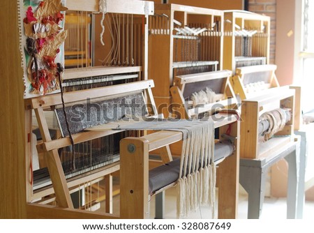 manual small weaving machine for making education arts and crafts textiles with local traditional materials and yarns in a university\'s fashion and textiles workshop in THAILAND