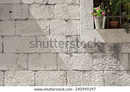 stone blocks wall with detail of flower decorated window