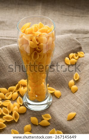 Art still life shell macaroni pasta on hessian linen fabric cloth background