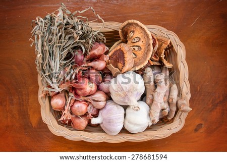 Thai seasoning such as garlic, shallots, dried quince and turmeric are in basket for cooking.