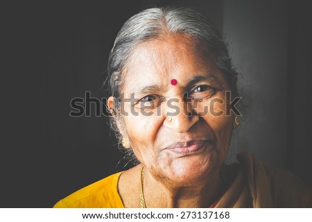An Old Indian beautiful traditional woman smiling at he camera