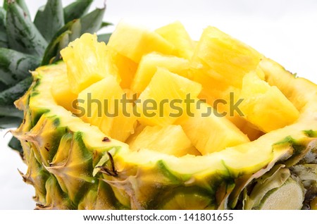 Cubed pineapple presented in its own bowl on white background.
