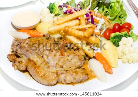 Grilled steaks with chips and vegetable salad ,Grilled steak, baked potatoes and vegetable salad