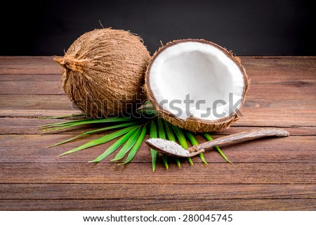Close up of a coconut and grounded coconut flakes On the wooden floor
