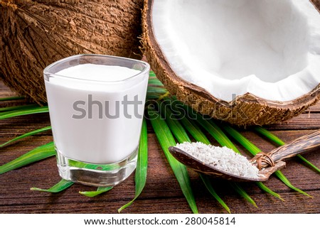 Coconut and coconut milk in glass on wooden table