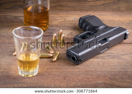 Gun with bullets and whiskey on the wooden floor