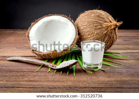 Coconut and coconut milk in glass on wooden table