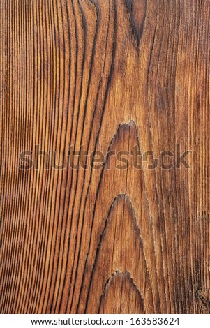 Old plank, with rough, layered surface, separated by annual growth lines, and lateral cracks.