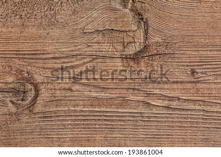 Photograph of old, roughly treated, weathered, cracked floorboard, with large wood knots.