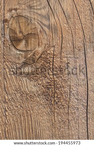 Photograph of old, roughly treated, weathered, cracked floorboard, with large wood knot.