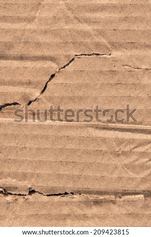 Photograph of recycle brown corrugated striped cardboard, coarse grain, obsolete, torn, grunge texture sample.