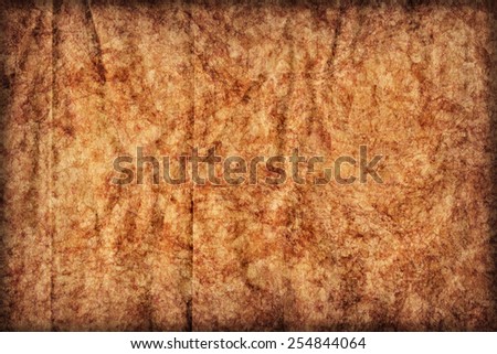Photograph of old Recycle Kraft Brown Paper, coarse grain, crushed crumpled, stained, mottled, vignette grunge texture sample.