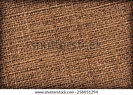 Photograph of raw, roughly woven, extra coarse grain, burlap vignette grunge texture.