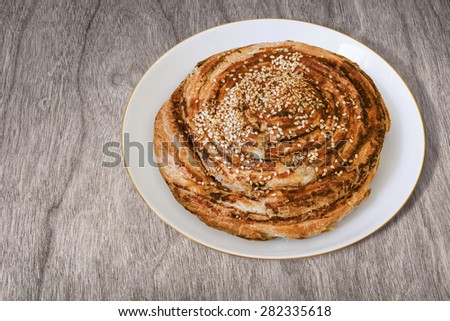 Croissant Sesame Puff Pastry Roll, in White Porcelain Plate, on Wood surface.