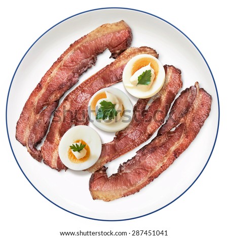 Fried Bacon Rashers with three hard boiled Egg slices with Mayonnaise and Parsley Leaves, on Porcelain Plate, Isolated on White Background.