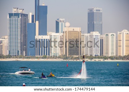 ABU DHABI - MARCH 31, 2013: Group of men doing water sports in front of skyline taken on March 31, 2013 in Abu Dhabi, United Arab Emirates.