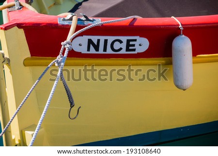 NICE MARCH 07, 2014: Nice word written on a yellow and red fishing boat taken on March 07, 2014 in Nice, France