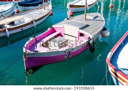 NICE MARCH 07, 2014: Pink fishing boat with pirate theme in azure water at the port of Nice taken on March 07, 2014 in Nice, France