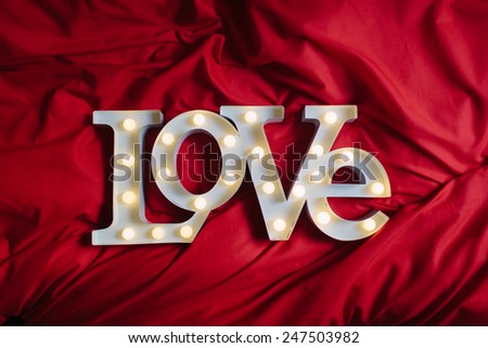 Love Sign Text Over a Red Bed Blanket