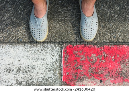 A rubber shoes and human leg on the road