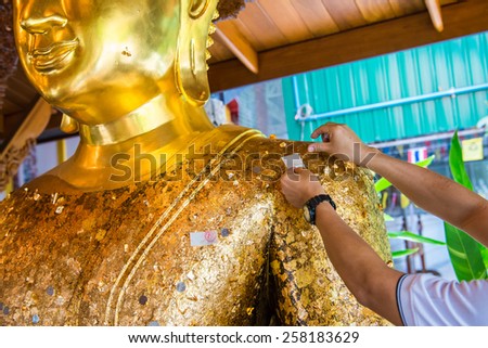 Thai tradition cover statue of Buddha with gold leaf and Hands were gilded