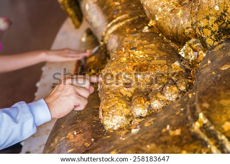 Thai tradition cover statue of Buddha with gold leaf and Hands were gilded