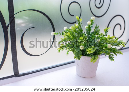 Small artificial tree in a pot. Concept image for interior design and decoration of home and office.