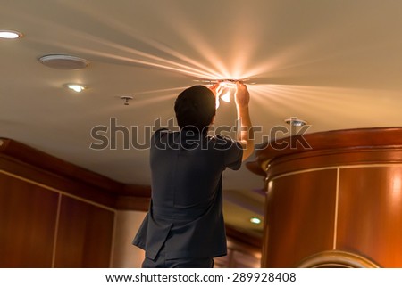 Electrician fixing lights in ceiling