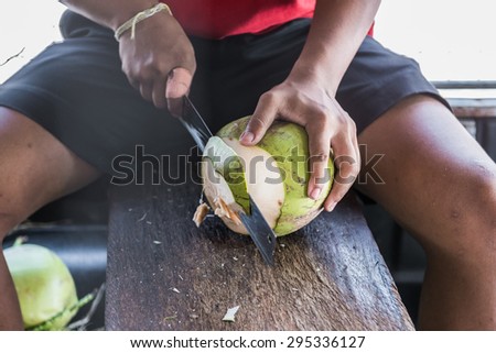 Man using knife to chopped coconut for juice