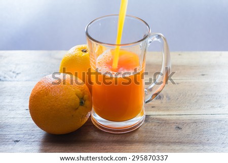 pouring orange juice into mug glass
