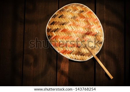 bamboo fan,thailand traditional handmade on wood background with shadow light