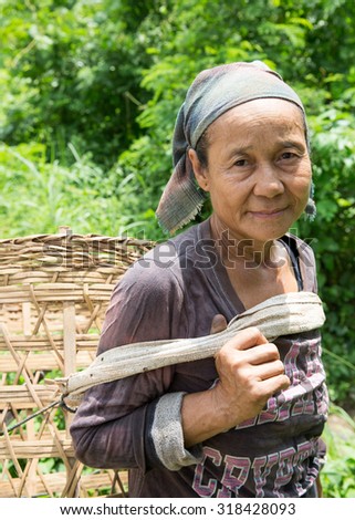 TAK, THAILAND - SEP 20 : Unidentified elder Karen woman carrying bamboo basket to store food for pigs at Tambol Maeh La, Tha Song Yang district, Tak, Thailand on SEPTEMBER 20, 2015