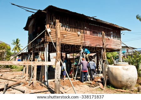 NAKHON RATCHASIMA, THAILAND - JANUARY26, 2011 : Unidentified men are elevating house and changing wooden pole to cement at Chumphuang district, Nakhon Ratchasima, Thailand