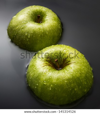 Two apples inside water with cool drops