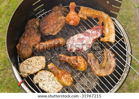 Sausages, beef and other meat on a barbecue
