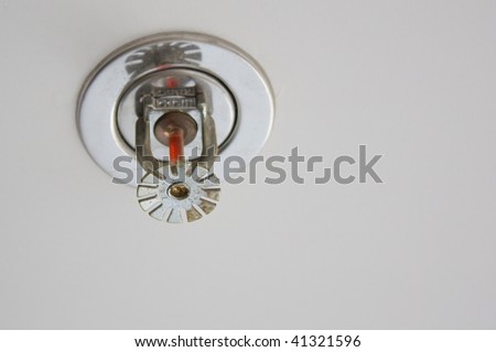 fire detector and extinguisher with gray ceiling as background