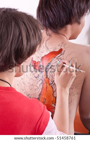 asian boy being body-painted