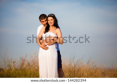 husband holding carefull his pregnant wife