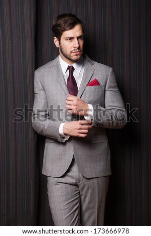 Elegant man posing at textile background