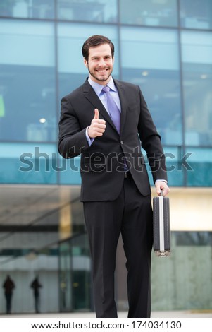 businessman happy after a good job in front of an office building
