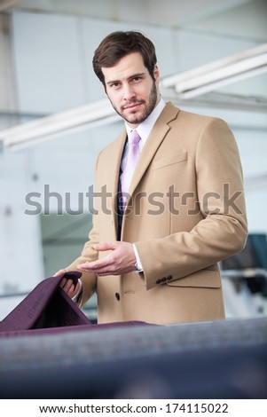 Business man wearing a business coat in a textile factory showing sample