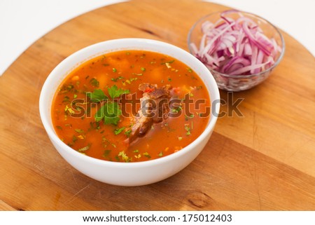 cup of pork soup on wooden plate and cup of onion, traditional