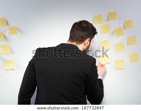 young businessman with postit reminder notes on the background
