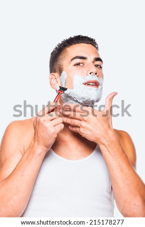 handsome man shaving his beard with a razor, on white background