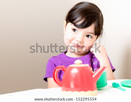 Happy young girl gets an idea as she drinks her tea