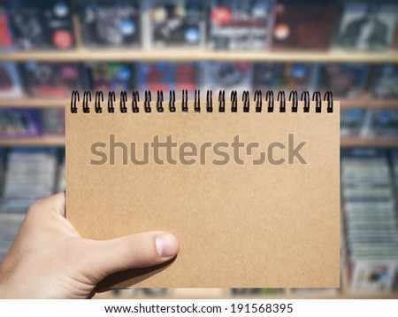 craft horizontal blank notebook in man hand and music store background