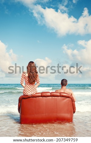 couple resting in leather couch on the beach