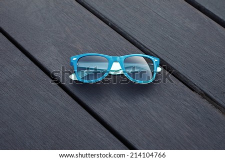 blue plastic sunglasses and wooden floor